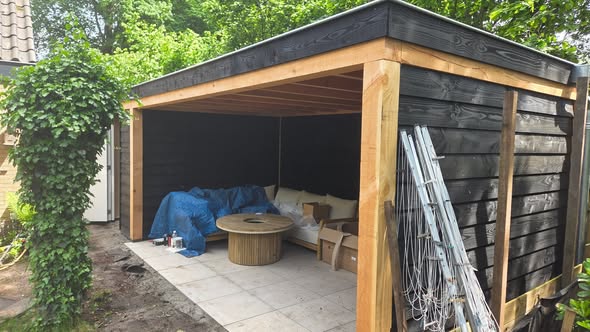 De tuinkamer van opzij, met de open zijde, eikkleurige staanders en een tegelvloer